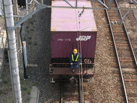 A brakeman helps to move a freight car at a railroad yard