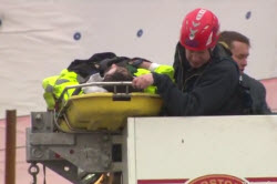 Boston firefighters use a ladder truck to rescue a worker who fell at an Allston construction site