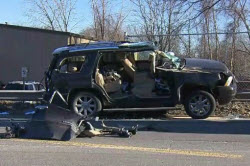 Daytime view of an SUV damaged after it hit a steel road plate in Worcester