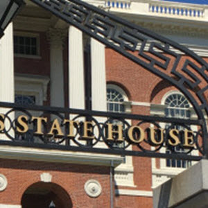 Close up view of the entrance to the Massachusetts State House showing the words "State House" on the iron arch over the entrance